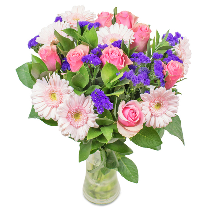 A vibrant floral bouquet, artfully presented in a clear glass vase, graces the image against a crisp white background-a signature of West Heath's refined aesthetics. The composition showcases approximately seven to nine soft-to-medium pink roses, many still tightly layered or beginning to open, their spiral shape distinct and classic. Five to seven pale pink gerbera daisies, recognizable by their generous round heads and lighter, almost white centres, enhance the bouquet's charm. Bright, vivid clusters of purple statice fill in the spaces, adding a punch of colour and texture, much like the lively accents found in West Heath's spring gardens. Deep green, lush foliage supports the bouquet with a sense of fullness and vitality, reminiscent of the neighbourhood's abundant greenery. The transparent vase displays the neatly trimmed stems and water below, symbolising freshness-just as if the bouquet was prepared for same-day delivery to a West Heath residence. Suitable for birthdays, anniversaries, Mother's Day, or as a stylish accent for a home or workspace, this arrangement conveys the heartfelt art and local pride of West Heath's floral artisans.